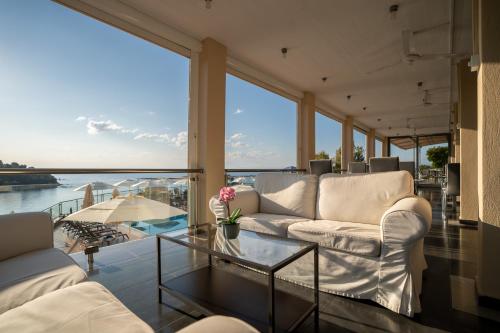 a living room with white furniture and a view of the water at La Luna Hotel in Troulos