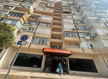 kobieta stojąca przed wysokim budynkiem w obiekcie Paraty de SteraM flats Torremolinos w mieście Torremolinos