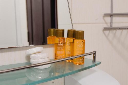 uno scaffale con quattro bottiglie di oli essenziali davanti a uno specchio di Pirin Peaks Residence - next to Ski Lift a Bansko