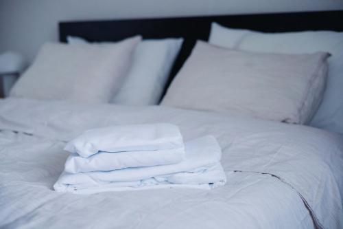 a pile of white towels sitting on top of a bed at Pirin Peaks Residence - next to Ski Lift in Bansko