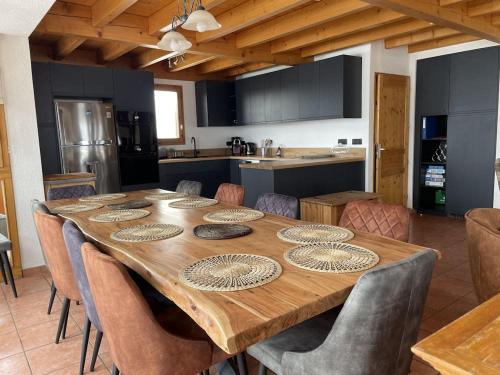 une grande table en bois avec des chaises dans la cuisine dans l'établissement Chalet Schuss, à Landry
