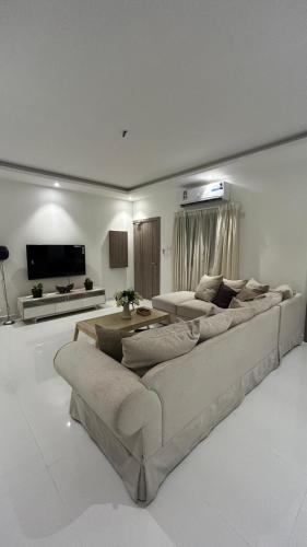 a living room with a large couch and a table at شقة فخمة مودرن in Jazīrat as Sāyah