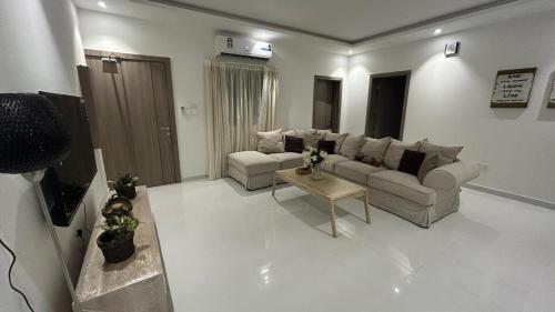 a living room with a couch and a table at شقة فخمة مودرن in Jazīrat as Sāyah