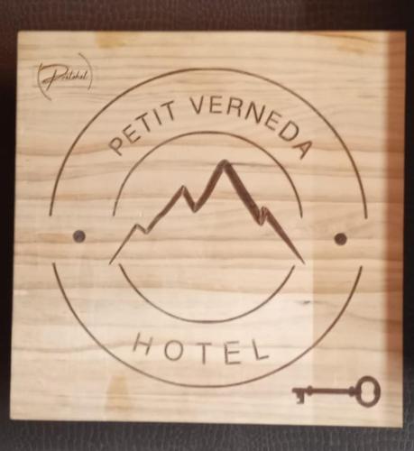 a sign for a hotel with a mountain and a compass at Petit Verneda in Casau