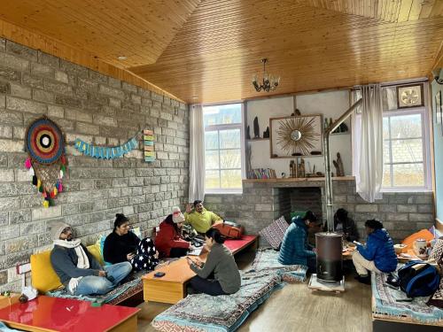 a group of people sitting on couches in a room at Flüstern Manali in Nagar