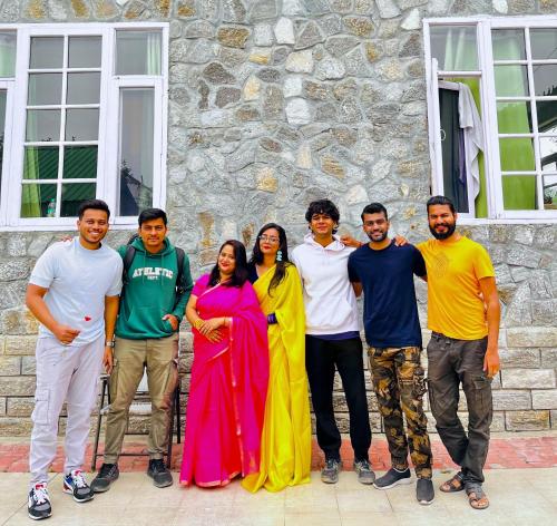 a group of people standing in front of a stone building at Flüstern Manali in Nagar