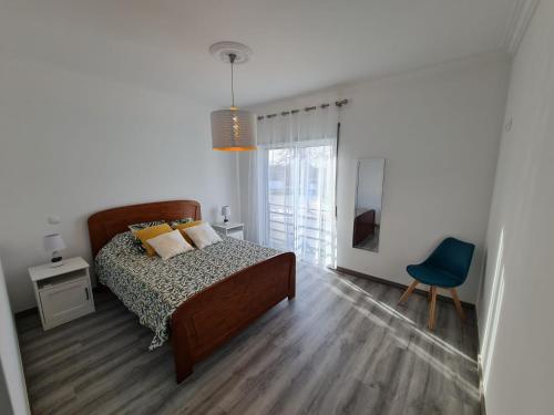 a bedroom with a bed and a blue chair at VILLA DO LIMAO in Tavira