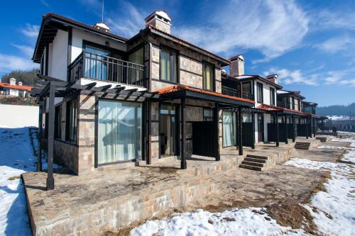 a house in the winter with snow at Holiday Village COOP Dobrinishte in Dobrinishte