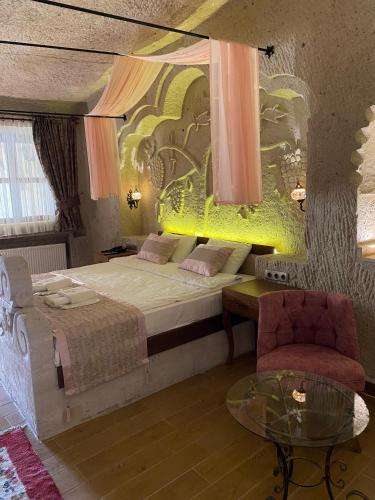 a bedroom with a bed and a chair and a table at Mesken Cave Suites in Nevsehir