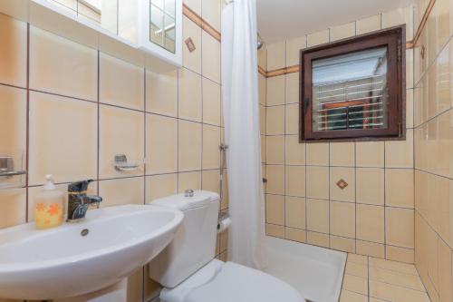 a bathroom with a sink and a toilet and a window at Apartments Magic Time in Podstrana