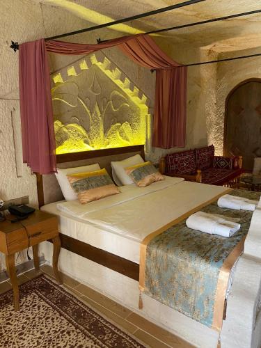 a bedroom with a large bed and a table at Mesken Cave Suites in Nevsehir