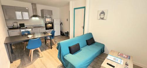 un salon avec un canapé bleu et une cuisine dans l'établissement Le Babord T2 étoilé, à Saint-Méloir-des-Ondes