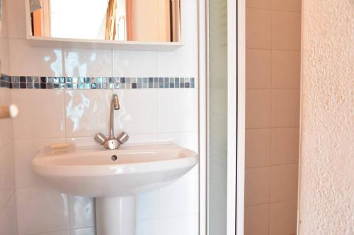 une salle de bain avec un lavabo et un miroir dans l'établissement Maison 3 pièces - Gruissan GA070-040, à Gruissan