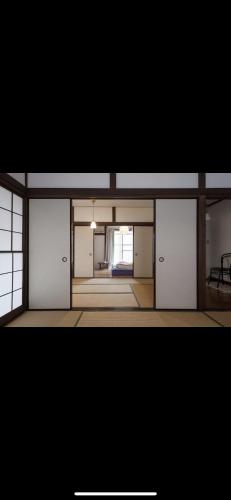 an empty room with white doors and a window at Yanesen Traditional Nagaya house in Tokyo