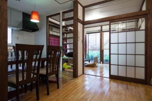 a kitchen and dining room with a table and chairs at Yanesen Traditional Nagaya house in Tokyo