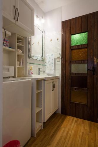 a kitchen with a sink and a wooden door at Yanesen Traditional Nagaya house in Tokyo