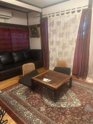 a living room with a couch and a table and chairs at Yanesen Traditional Nagaya house in Tokyo