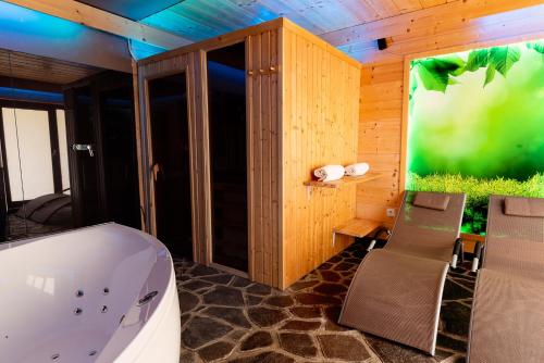 a bathroom with a tub and a table and chairs at Horská Chata Vasko in Ždiar