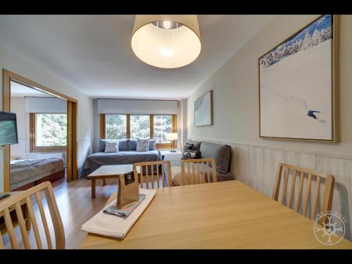a dining room and living room with a table and chairs at BOLQUER de Alma de Nieve in Naut Aran
