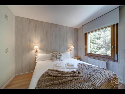a bedroom with a large bed and a window at BOLQUER de Alma de Nieve in Naut Aran