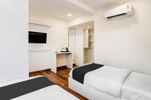 a white room with a bed and a desk at Super Townhouse HSR Layout Formerly Seven Olives in Bengaluru