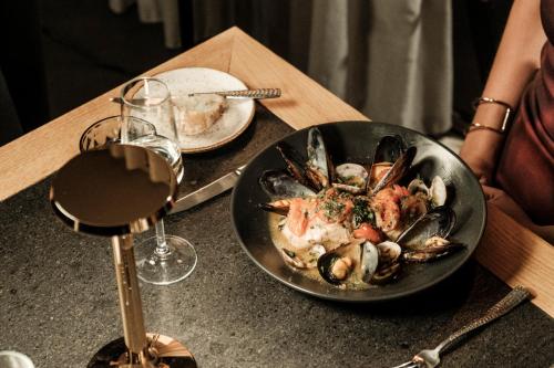 a bowl of seafood on a table with a glass of wine at Fitch Hotel in St Julian's