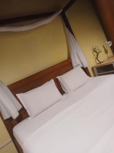 two beds with white pillows in a room at Hotel Lang Hoose in George Town