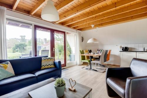 ZwiggelteにあるZomertortel I Vrijstaande Vakantiewoningの青いソファとテーブルのあるリビングルーム