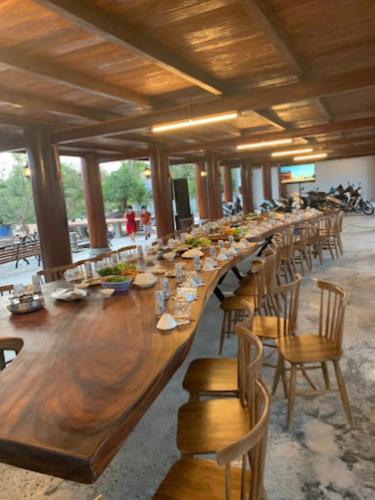 a long wooden table in a room with chairs at Dalis Waterfall Homestay in Lagi