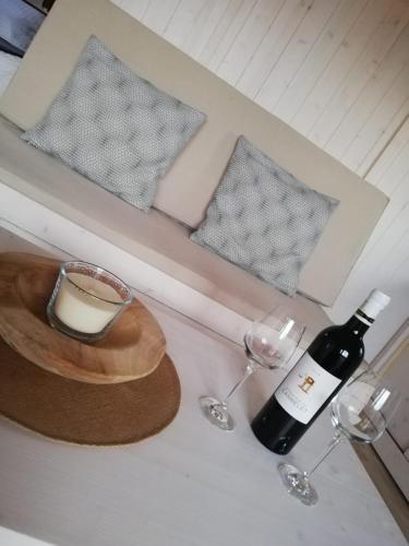 a bottle of wine and two glasses on a counter at Les Cabanes de Lara in Ménesplet