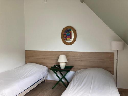 - une chambre avec 2 lits et une table avec un miroir dans l'établissement Gîte D'ANDREZEL, à Andrezel