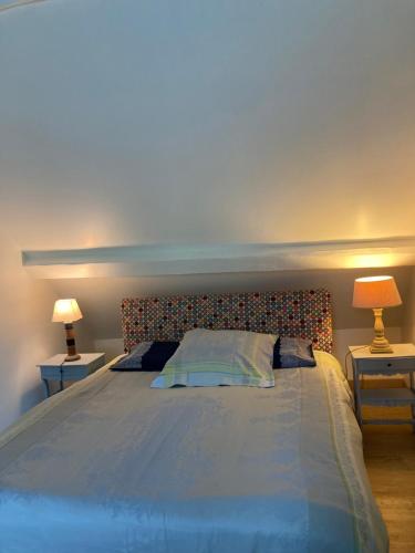 une chambre avec un grand lit avec deux lampes dans l'établissement Gîte D'ANDREZEL, à Andrezel