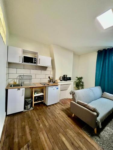 un salon avec un canapé et une cuisine dans l'établissement Appartement T2 proche gare - DABNB, à Limoges