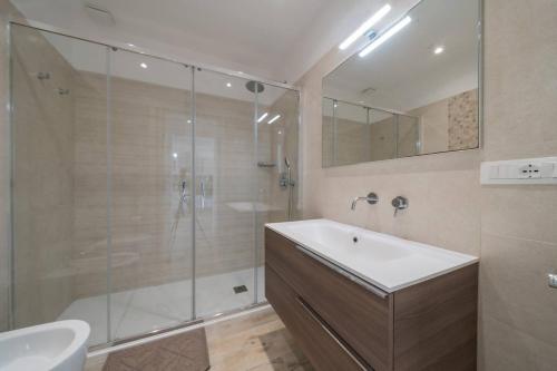 a bathroom with a glass shower and a sink at Penthouse Venere su 2 piani - Leuca by Salento Pri in Leuca
