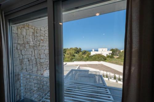 a sliding glass door with a view of a building at Penthouse Venere su 2 piani - Leuca by Salento Pri in Leuca