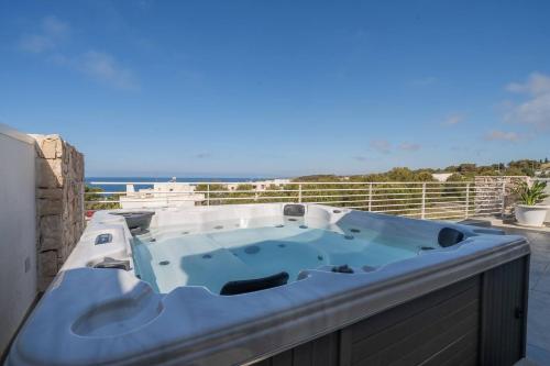 a hot tub on a balcony with the ocean in the background at Penthouse Venere su 2 piani - Leuca by Salento Pri in Leuca