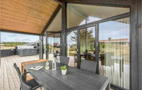 an open patio with a table and chairs on a deck at Nice Home In Hvide Sande With Sauna in Bjerregård