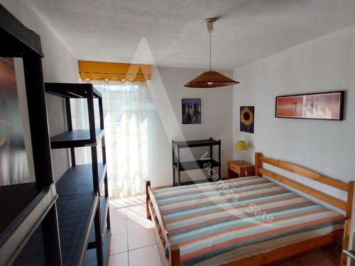 une chambre avec un lit dans une pièce avec une fenêtre dans l'établissement CONFORTABLE T2 EN FRONT DE MER, PARKING, WI-FI, à Sète