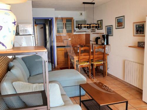 un salon et une cuisine avec un canapé et une table dans l'établissement CONFORTABLE T2 EN FRONT DE MER, PARKING, WI-FI, à Sète