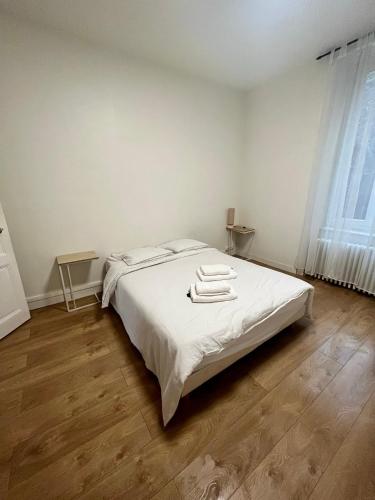 une chambre avec un lit blanc avec des serviettes dessus dans l'établissement Appartement T2 proche gare - DABNB, à Limoges