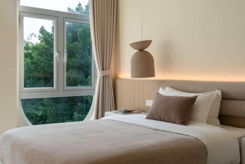 a bedroom with a bed and a large window at 礼橖LoveTime·美学海景民宿（较场尾大鹏所城店） in Shenzhen