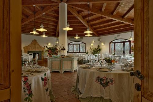 Habitación grande con mesas con manteles blancos. en Villa Belfiore, en Ostellato
