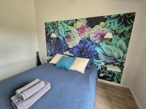 - une chambre dotée d'un lit bleu et d'une peinture murale dans l'établissement La Terrasse de Rochard Maison 6p proche Puy du Fou, à Mortagne-sur-Sèvre