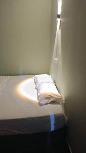 a bedroom with a bed with a light on the wall at Health Homestay KL in Kuala Lumpur