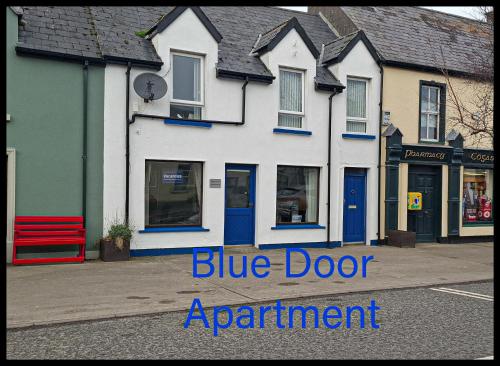 a blue door apartment building on a street at Blue Door Apartment Main St, Carrigart, F92HC04 in Carrigart