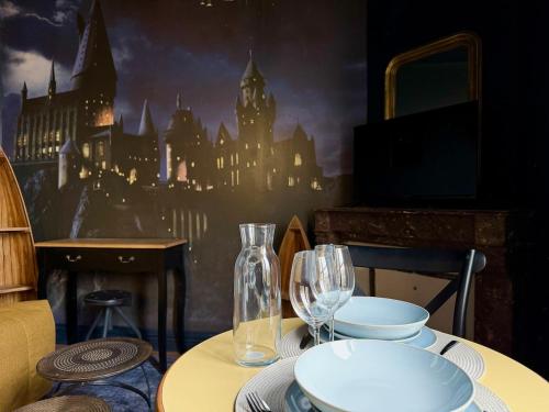 une table avec des assiettes et des verres à vin dessus dans l'établissement La traversée des sorciers, à Reims