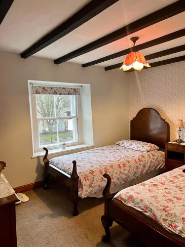 a bedroom with two beds and a window at Lark Cottage in Pickering