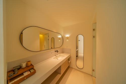 a bathroom with a sink and a mirror at 礼橖LoveTime·美学海景民宿（较场尾大鹏所城店） in Shenzhen
