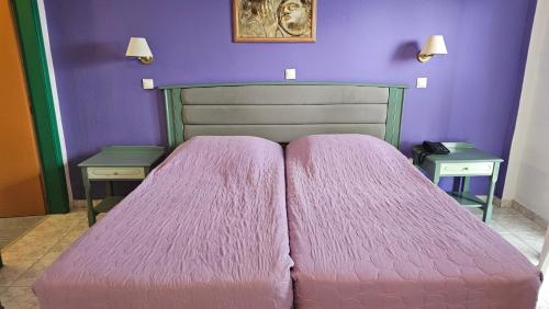 a bedroom with a pink bed with two tables at Arte Annapolis Inn in Rhodes Town