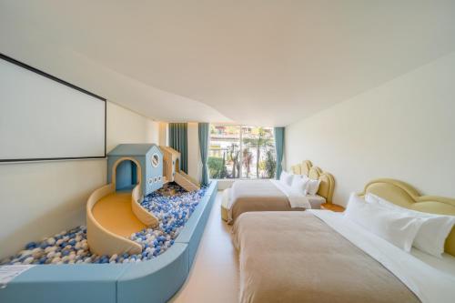 a hotel room with two beds and a playroom at 礼橖LoveTime·美学海景民宿（较场尾大鹏所城店） in Shenzhen